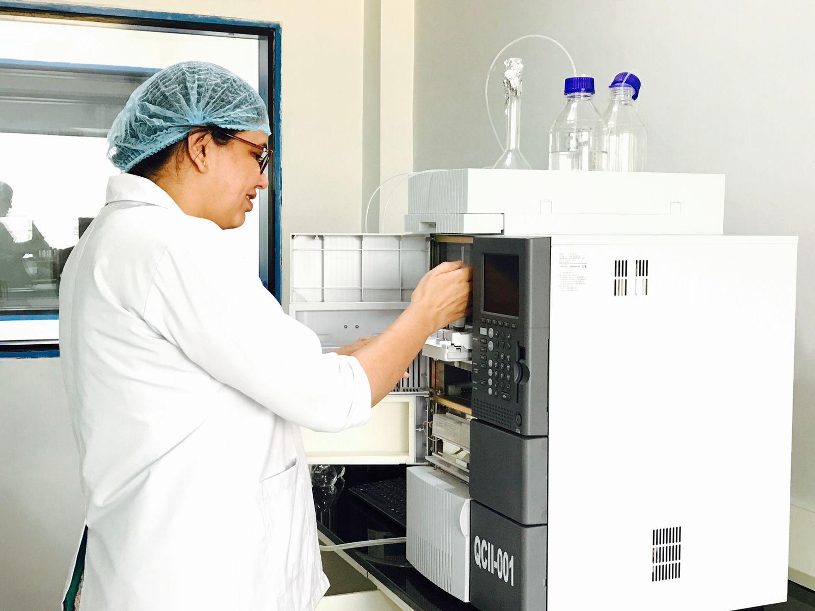 A technician operating a gas chromatograph in an analytical quality-control laboratory