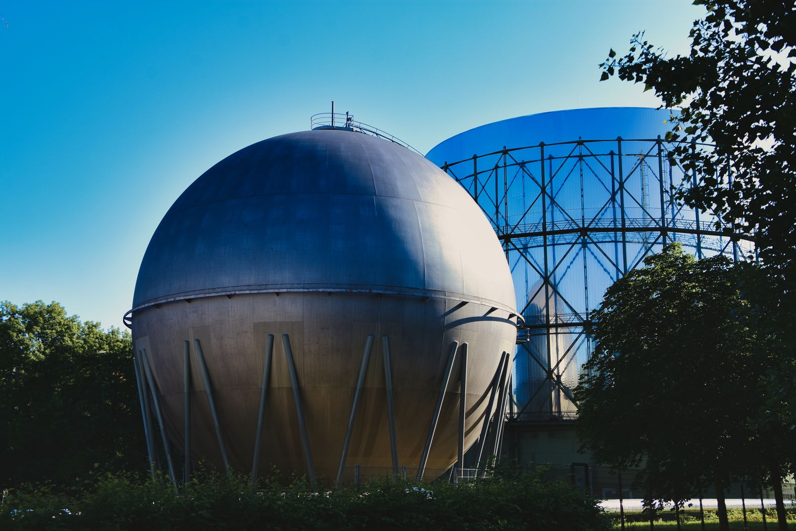 A spherical pressure vessel and a framed gas holder at a gas storage site