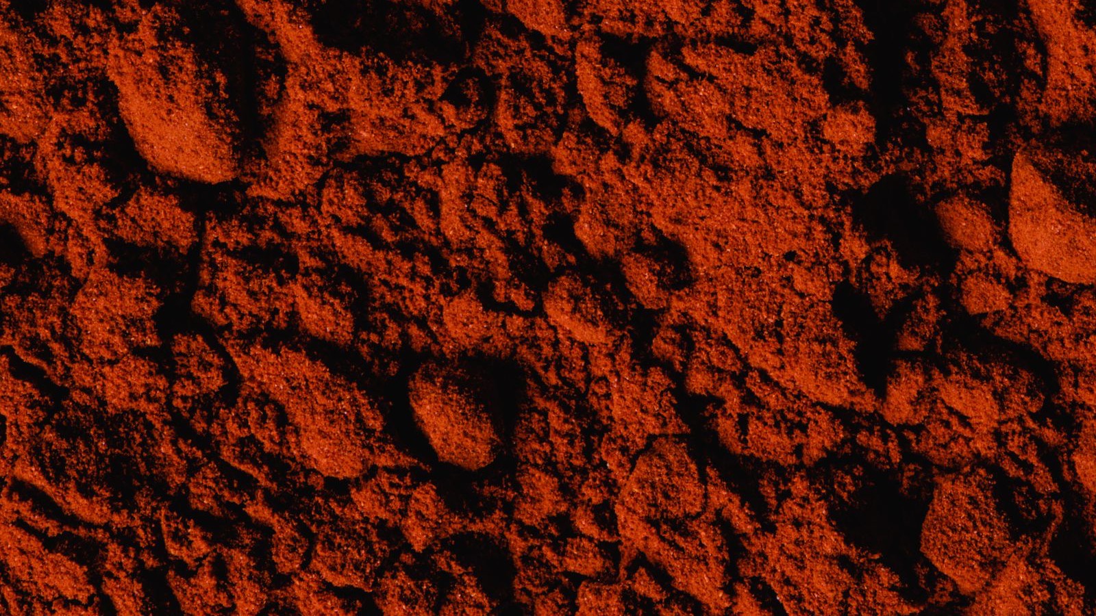 Close-up of a bed of fine red iron oxide pigment powder