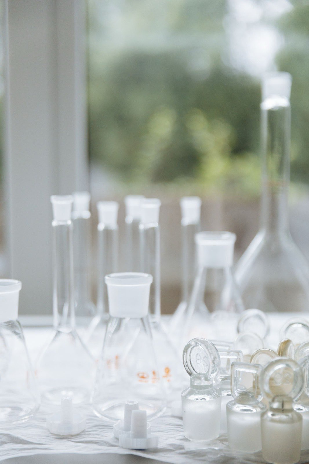 Volumetric flasks and stoppered bottles arranged on a bench